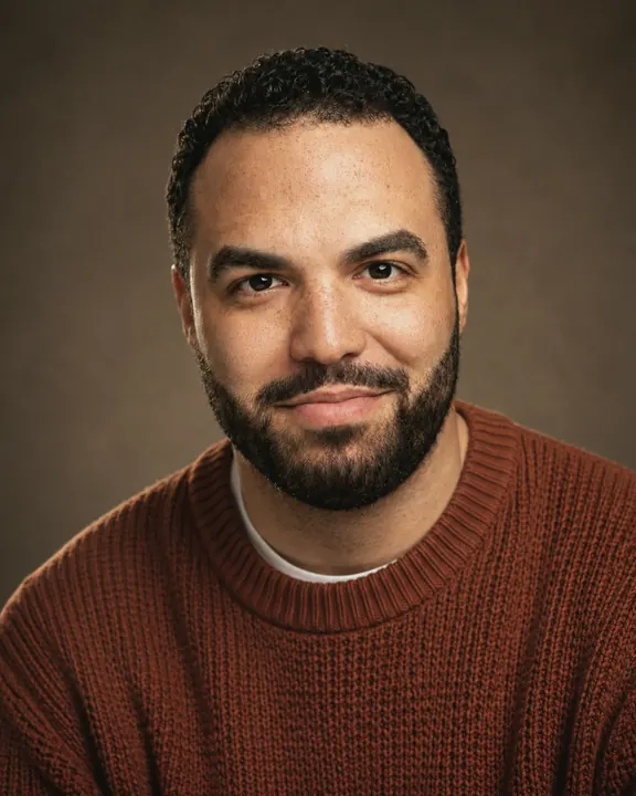 Portrait two: me in a rust knit sweater against a brown backdrop.